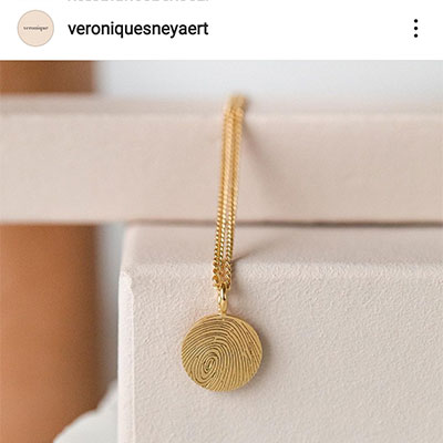 Pendentif circulaire de mémoire en or empreinte de doigt sur présentoir par Véronique Sneyaert