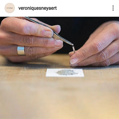 Mains travaillant sur un établi pour concevoir un bijou de mémoire, Véronique Sneyaert