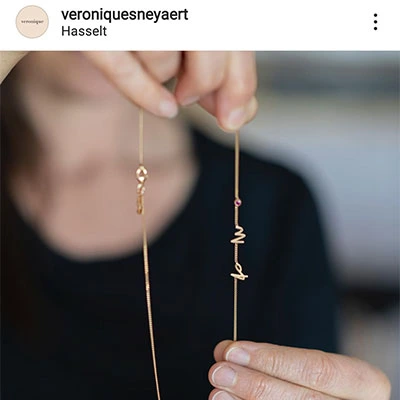 Femme montrant un fin collier de mémoire, création de la bijoutière Véronique Sneyaert