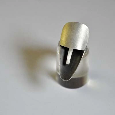 Bague artisanale design en métal poli présentée