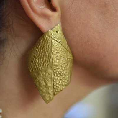 Grande boucle oreille texturée en forme de feuille dorée portée